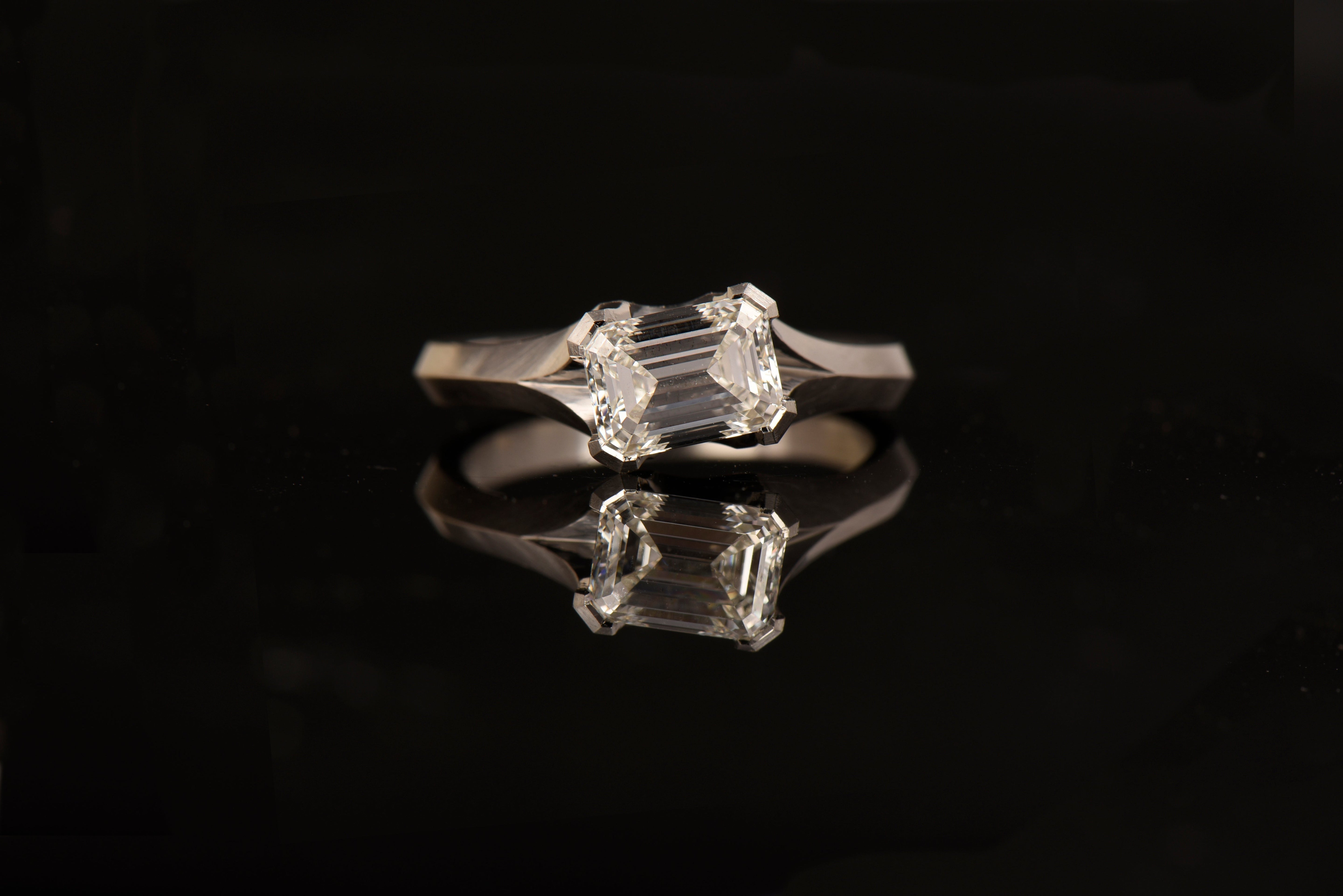 Unique bespoke engagement ring with emerald cut diamond