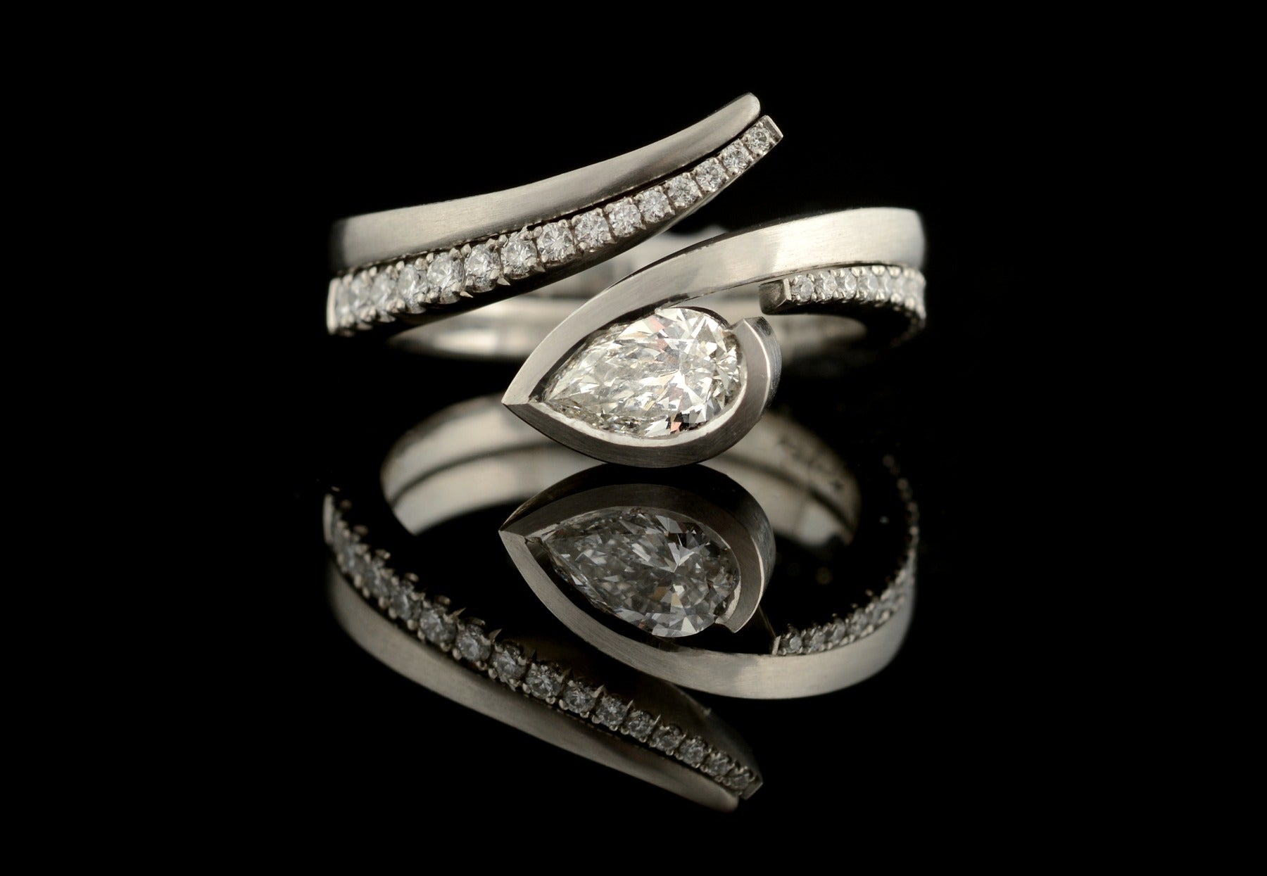 Twist pear shape white diamond platinum engagement ring and white diamond pave set fitted wedding ring